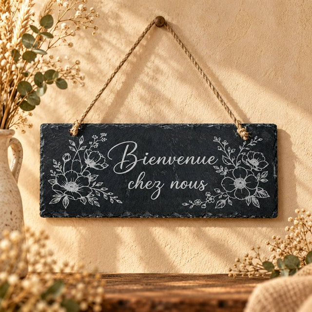 Pancarte en ardoise gravée Bienvenue chez nous avec décor floral, suspendue à une cordelette