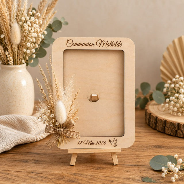 Cadre photo en bois gravé pour cérémonie religieuse avec prénom date et colombe, posé sur son chevalet
