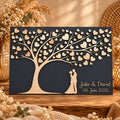 Tableau souvenir mariage en bois avec fond gris foncé, arbre chargé de cœurs et silhouettes des mariés en bois clair en relief
